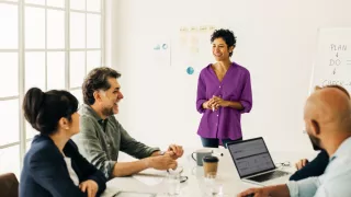 A woman presenting to colleagues in a conference room